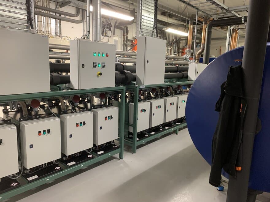 Bildet viser kjøleriggen i maskinrommet i kjelleren under veksthus 6 i Åsbakken. Det var et tungt, stort og nøye planlagt arbeid å få denne kolossen på plass.
