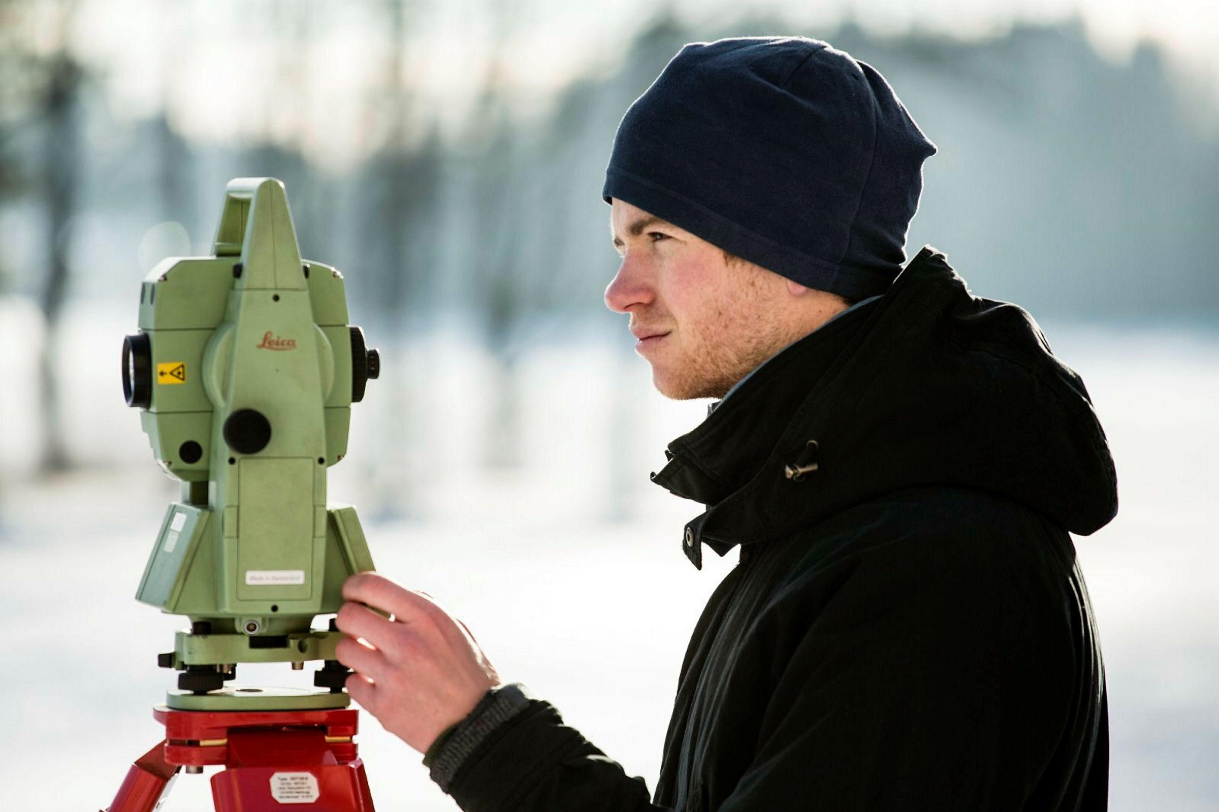 Studenter i geometikk gjør landmåling utenfor Urbygningen ved UMB. På bildet: Jørgen Loe Kvalberg.