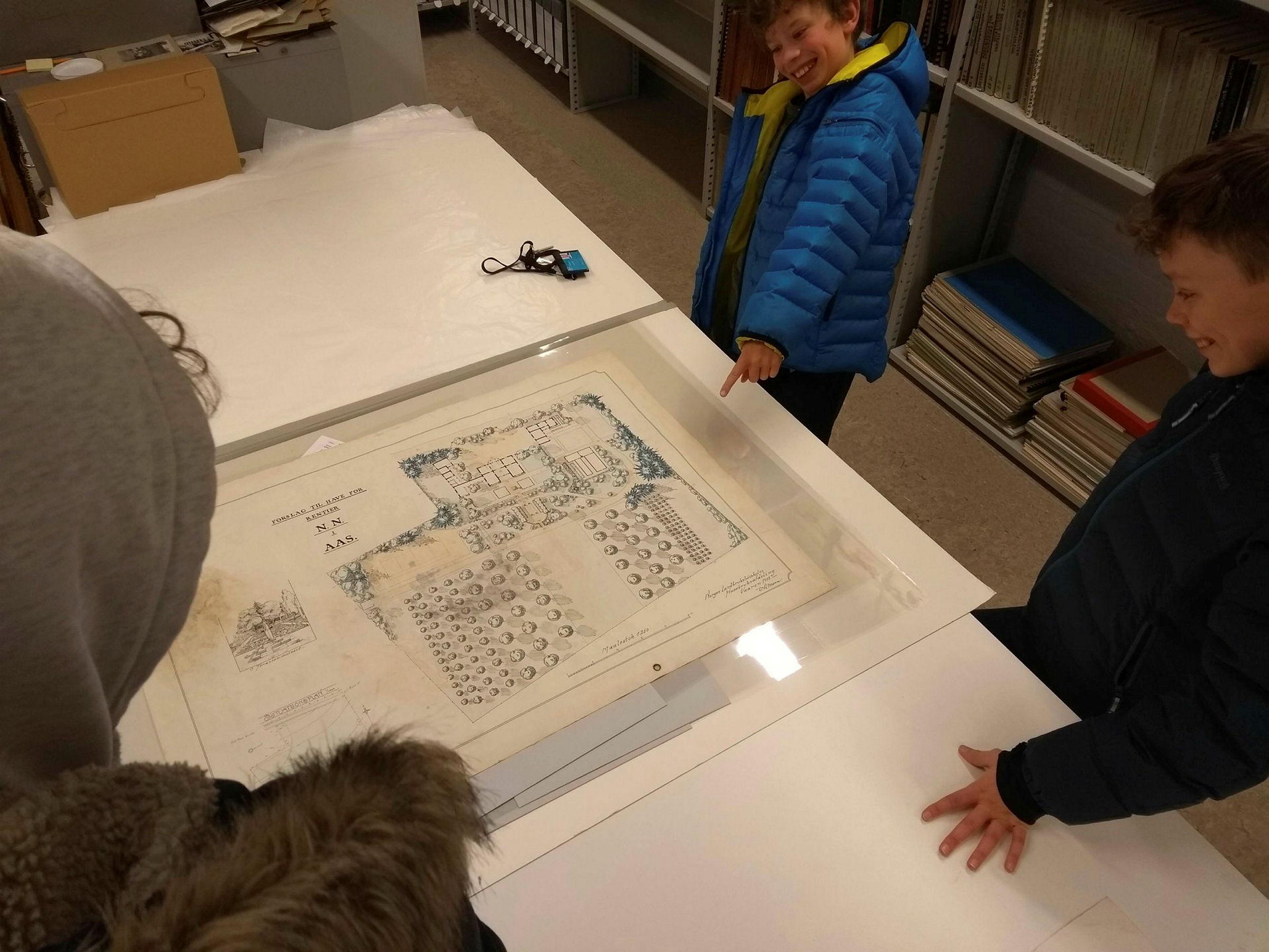 Arkivet knytter dagens samfunn til fortiden (På bildet: Barn ser på historiske planskisser).