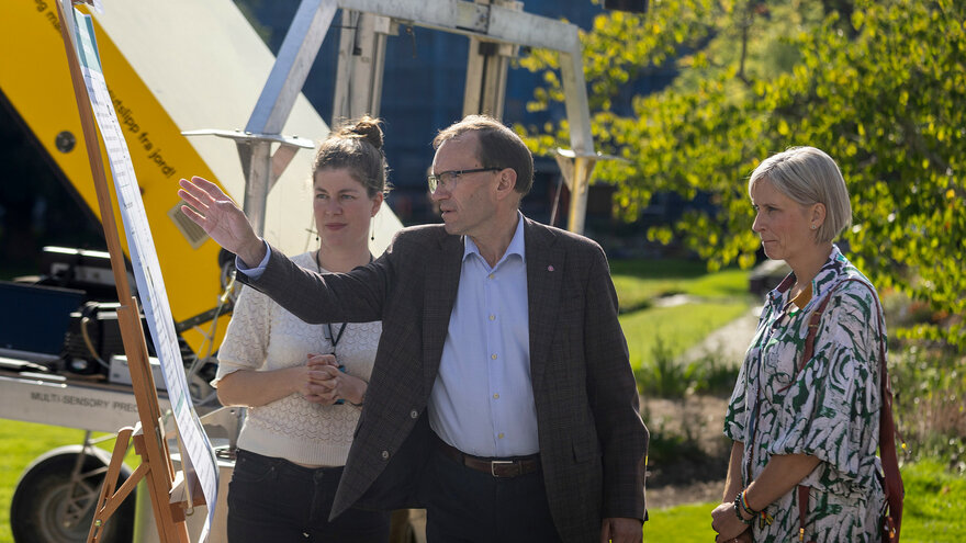 Klima- og miljøvernminister Espen Barth Eide peker med armen ut mot lystgassroboten til Elisabeth Gautefall Hiis.