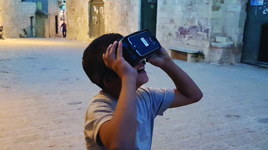 A child experiencing VR demonstrations of a heritage site in a workshop in Jenin, Palestine