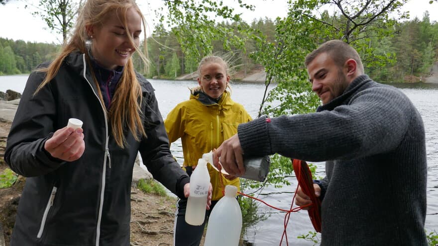Studenter på miljø og naturressurser som fyller vannprøver. 